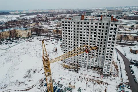 Construction of a multi-storey building with cranes and builders top view Stock Photos