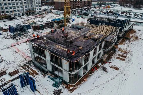 Construction of a multi-storey building with cranes and builders top view Stock Photos