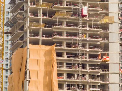 Construction of a multi-storey building in Dubai. Unfinished building facade Stock Photos