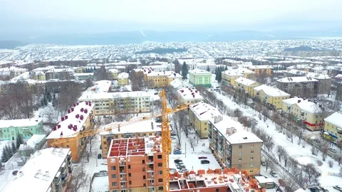 Construction of a multi-storey building in a small town, yellow tower crane Stock Footage 121583121