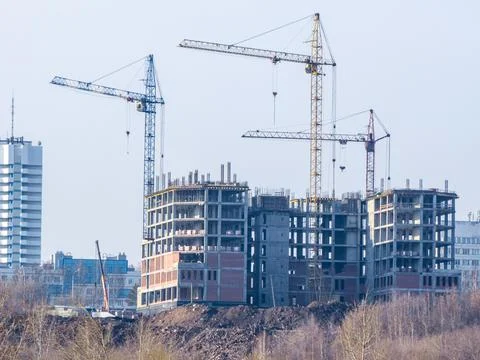 Construction of a multi-storey building using tower cranes Stock Photos