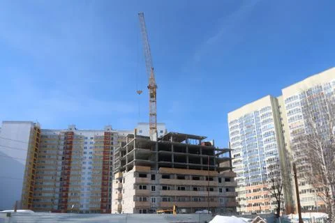 Construction of multi-storey house and industrial building crane on backgroun Stock Photos