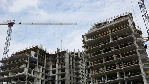 Construction of multi-storey houses. Construction crane turns against the sky Stock Footage 77142211