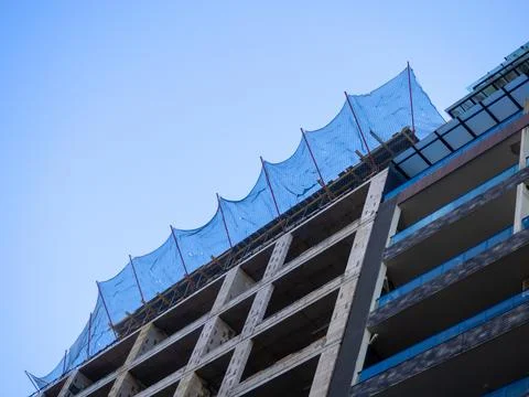 Construction nets on an unfinished building. Construction industry. Cement .. Stock Photos