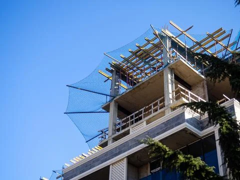 Construction nets on an unfinished building. Construction industry. Cement .. Stock Photos