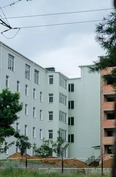 Construction of a new apartment complex across from overcast skies. The gray- Stock Photos