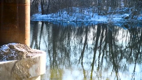 Construction of a new automobile bridge across the river, on a sunny winter d Stock Footage 320998095