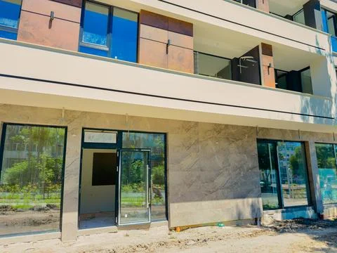 Construction of a new building with modern design and glass windows in a de.. Stock Photos