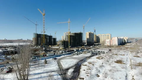 Construction of a new residential area in front of road traffic covered in snow. Video stock 94181882
