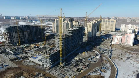 Construction of a new residential area in front of road traffic covered in snow. Video stock 94182787