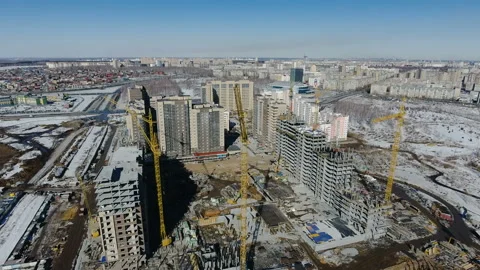Construction of a new residential area in front of road traffic covered in snow. Video stock 94185376