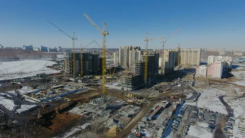 Construction of a new residential area in front of road traffic covered in snow. Video stock 94193392