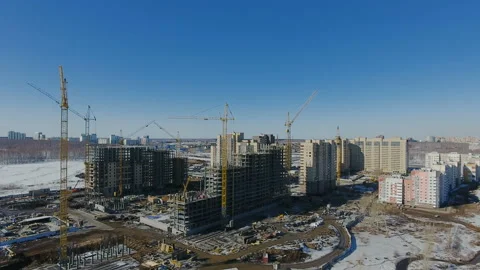 Construction of a new residential area in front of road traffic covered in snow. Video stock 94193763