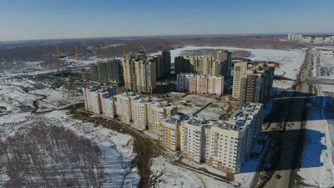 Construction of a new residential area in front of road traffic covered in snow. Video stock 94194839
