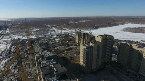Construction of a new residential area in front of road traffic covered in snow. Video stock 94194841
