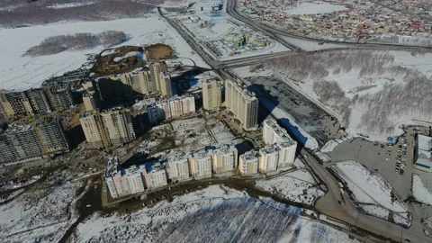 Construction of a new residential area in front of road traffic covered in snow. Video stock 94196007