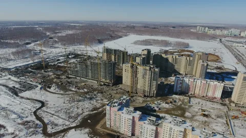Construction of a new residential area in front of road traffic covered in snow. Video stock 94196459