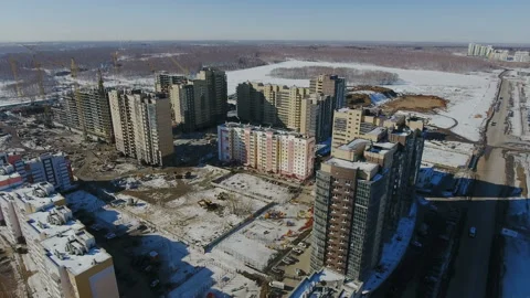 Construction of a new residential area in front of road traffic covered in snow. Video stock 94197089