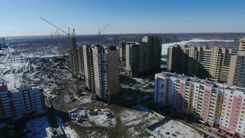 Construction of a new residential area in front of road traffic covered in snow. Video stock 94201460