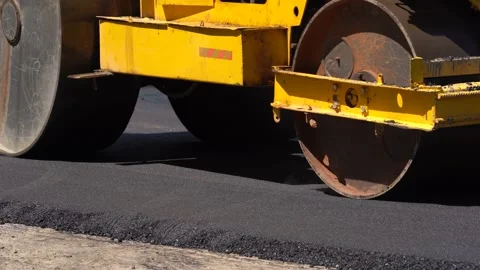 Construction of new road. A layer of freshly laid asphalt in the rays of the Stock Footage 172537934