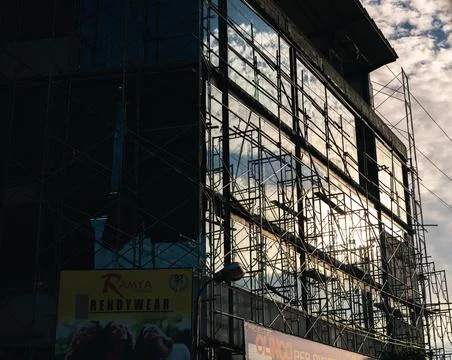 Construction of a new tall building, reflection of the bright skies from the  Stock Photos