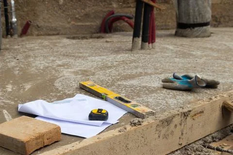 Construction objects and tools perched in concrete floor on construction site Stock-Fotos