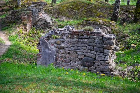 The construction of old bricks and stones from the castle ruins in the green Stock Photos