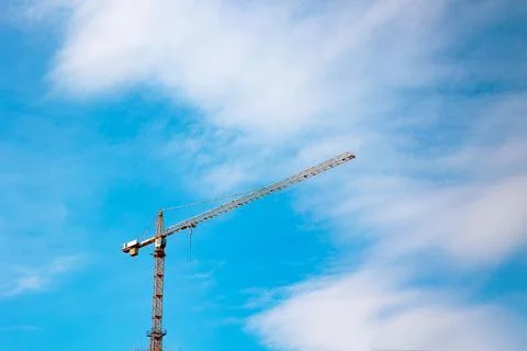 Construction or development. Tower crane with partly cloudy sky background. Stock Photos