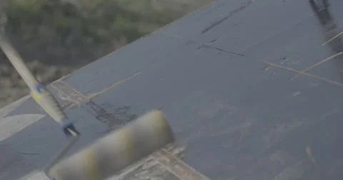 Construction, painting, construction roller, black paint, sunny weather Stock Footage 305641428