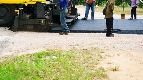The construction of paved road by workers and Asphalt Paver Machines i Stock Footage 202298980