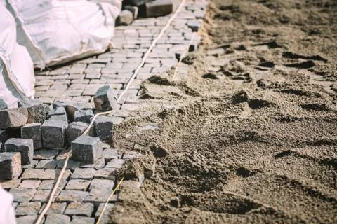 Construction of pavement path, road or sidewalk with cobblestone granite stones Stock Photos