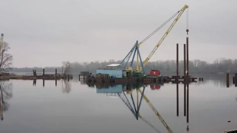 Construction of a pedestrian bridge. Welders on the river weld metal structures. Stock Footage 245762271