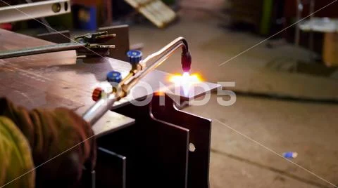 Construction plant. A worker start heating up the detail with a machine for the Stock Photos