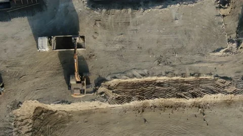 Construction plot with an excavator loading soil into a dump truck. The path for Vídeos de archivo 159963475