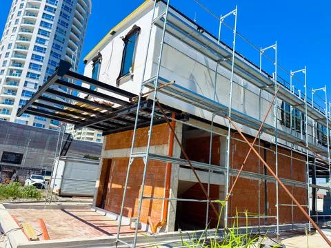 Construction process of a building under scaffolding in a busy urban area d.. Stock Photos