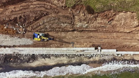 Construction process of a coastal structure along the shoreline with machinery Stock Footage 336616194