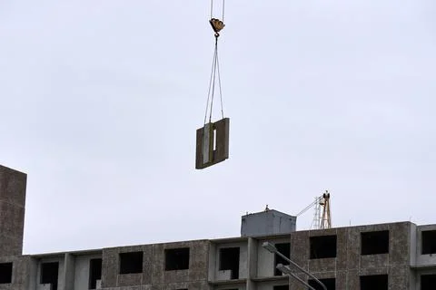 Construction process: hoisting a reinforced concrete panel in the air Stock Photos