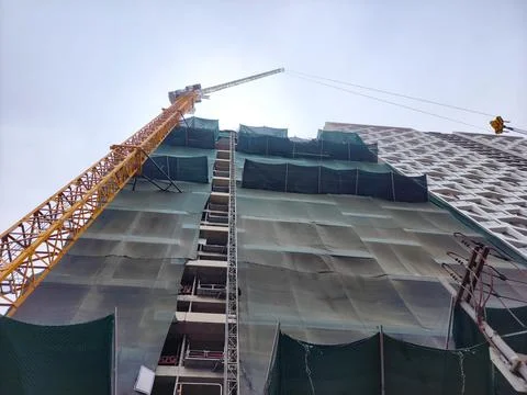 Construction process of an office building with a giant tower crane Stock Photos
