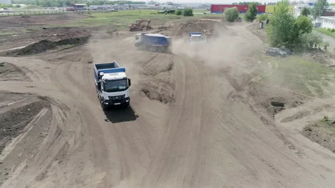 The construction process. Scene .Large trucks drive and build something on flat Stock Footage 172315303