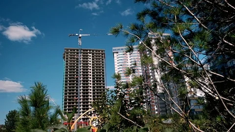 Construction process of skyscraper and new apartments with cranes on a blue sky Stock Footage 110417431