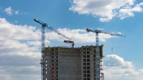 Construction process of skyscraper with cranes on the roof. Stock Photos