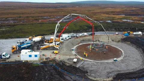Construction process of wind generator foundations with heavy machinery in .. Stock Photos