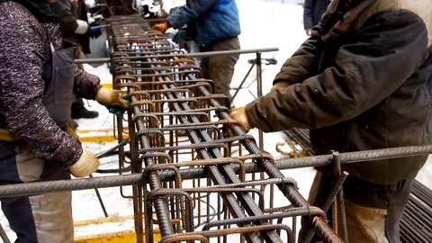 Construction process. Workers using steel wire and pincers to secure rebar Stock Footage 125396663