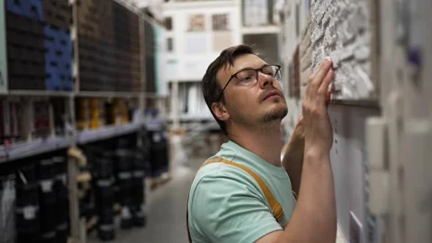 Construction professional reviewing stone cladding samples at building supply Stock Footage 310905520