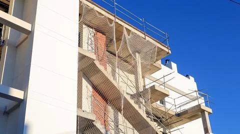 Construction progress on a building with safety netting and scaffolding und.. Foto stock