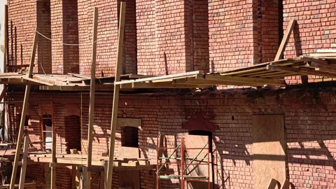 Construction in progress, building with scaffolding and workers Видео 344893867