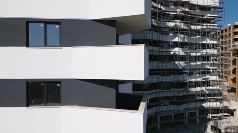 Construction progress of a modern residential building with scaffolding in a Stock Footage 304079041