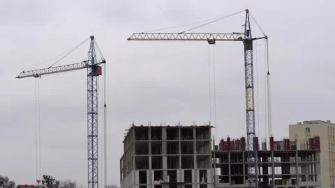 Construction progress on a new building with cranes in an urban area on a cloudy Stock Footage 320436556