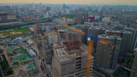 Construction progress of a skyscraper in a bustling urban area during sunset Stock Footage 311844086