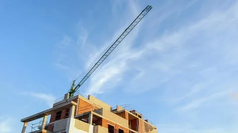Construction progress with a tall crane towering over a building reaching f.. Foto stock